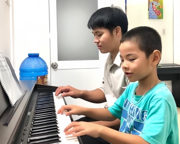 học viên nhỏ siêng năng học piano cùng thầy